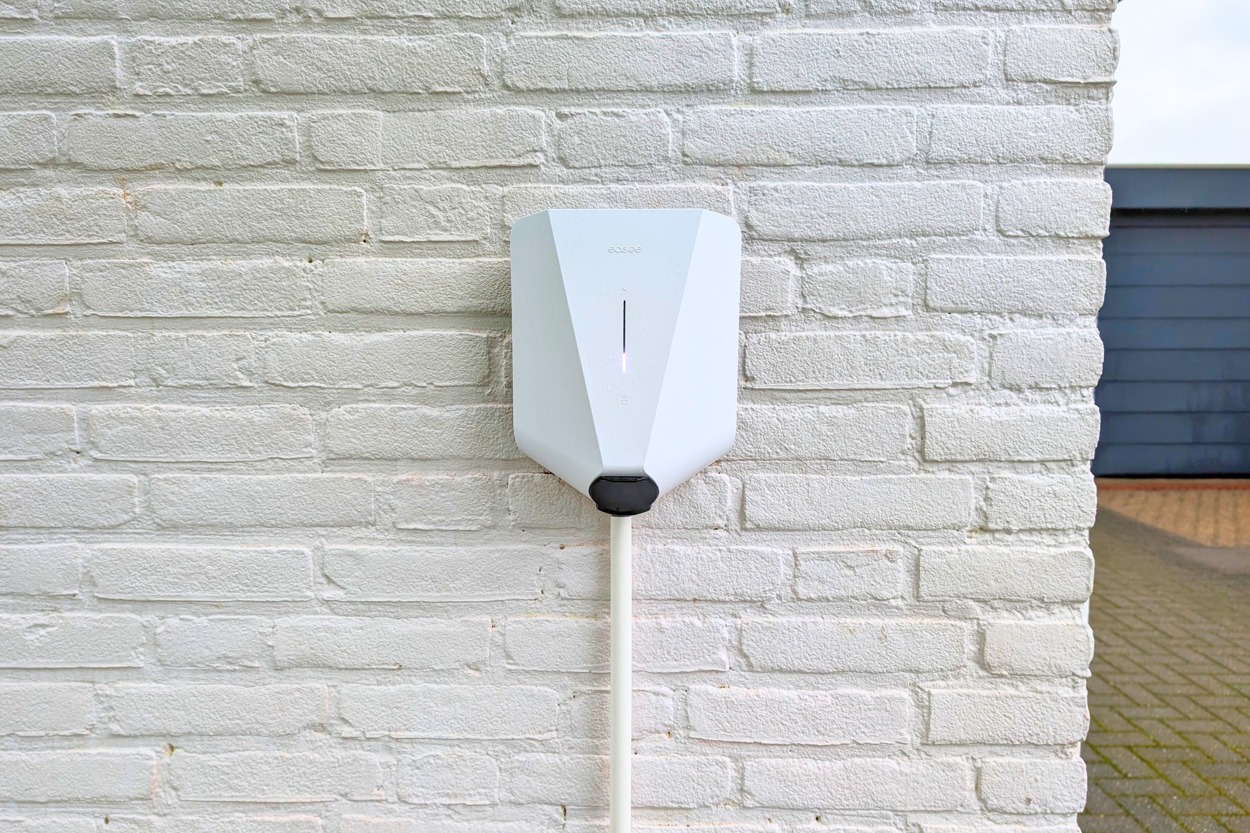 Door Energiek gemonteerde Black Easee chargers mounted on concrete wall.